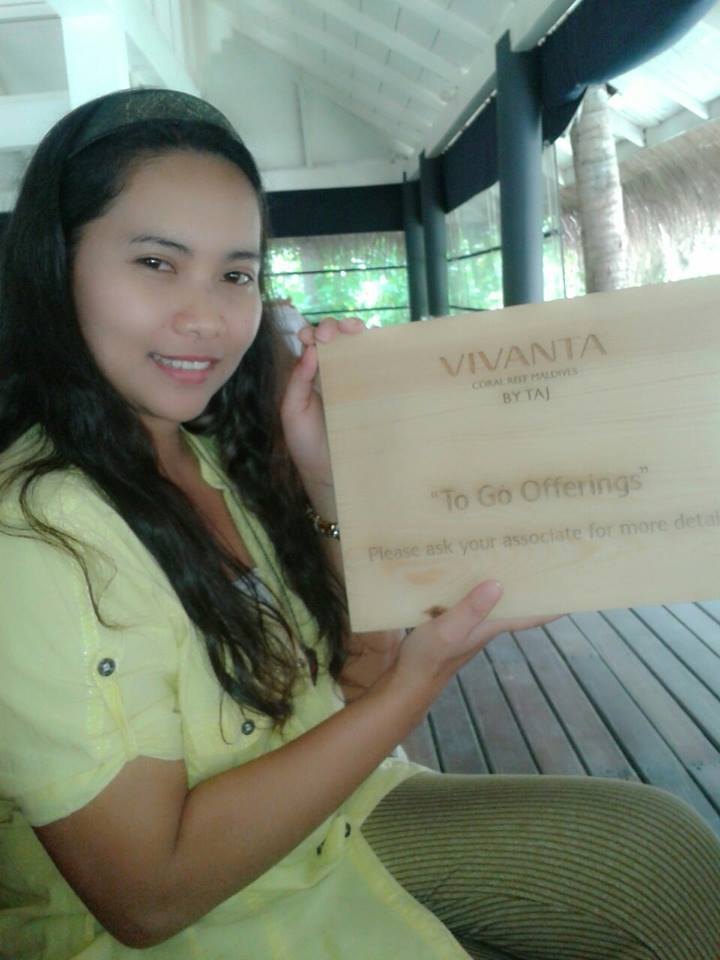 Meliza holding a Vivanta by Taj resort information sign